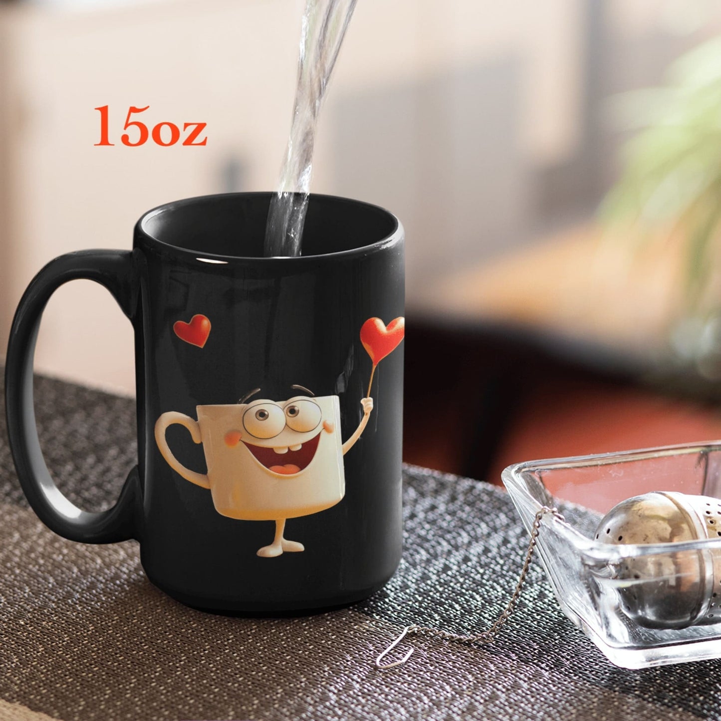 15oz black ceramic mug with happy face and heart design, hot water being poured, tea infuser nearby.