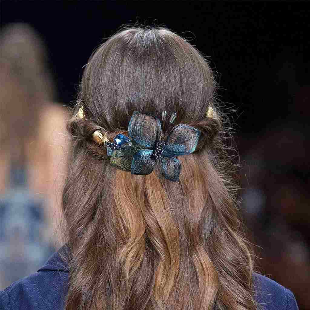 Elegant handmade blue floral hair clip by Mistofu, adding style and sophistication to a woman's braided hairstyle.