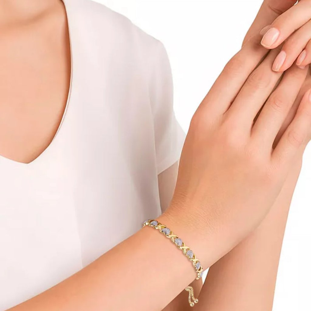 Elegant model wearing a gold bracelet with heart and infinity accents, highlighting its adjustable fit and timeless charm.