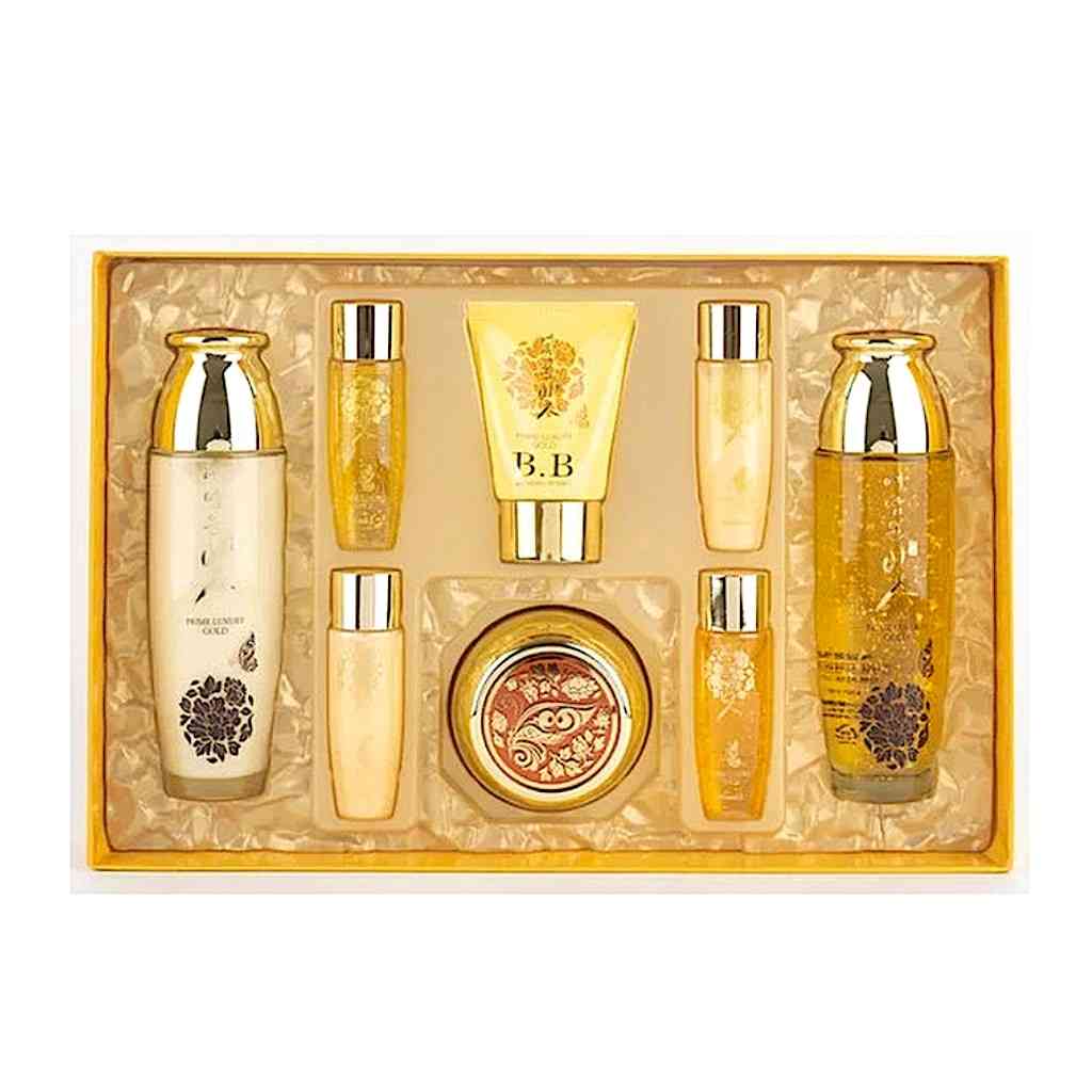 Luxury skincare gift set with gold packaging, includes various creams, lotions, and serums in elegant bottles and tubes.