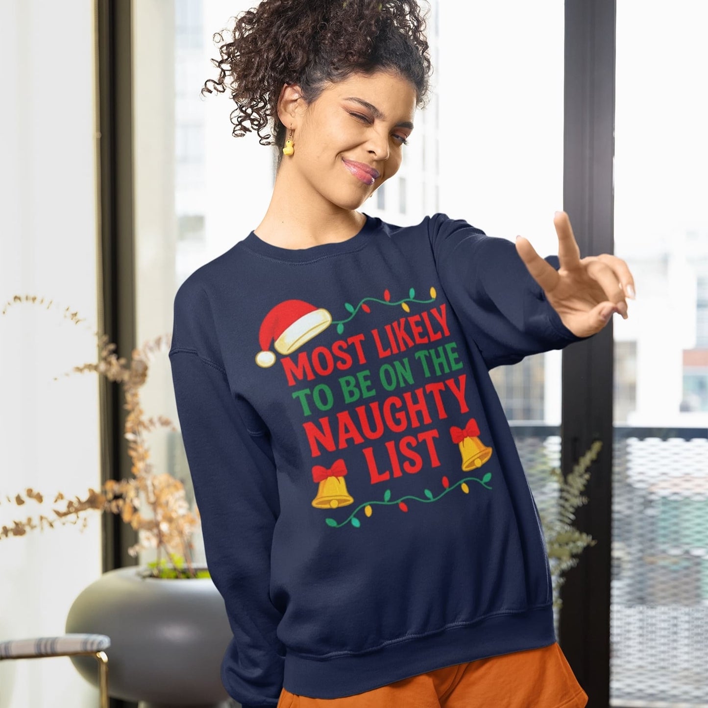 Woman wearing Gildan 18000 Navy Christmas sweatshirt with “Most Likely to Be on the Naughty List” design, funny unisex holiday sweater gift.