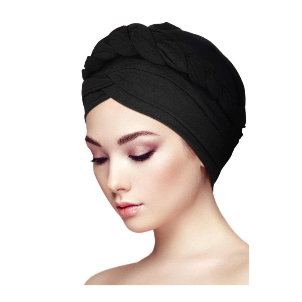 Chic woman wearing a pre-tied black turban head wrap with a stylish braided design, presenting an elegant and fashionable look.