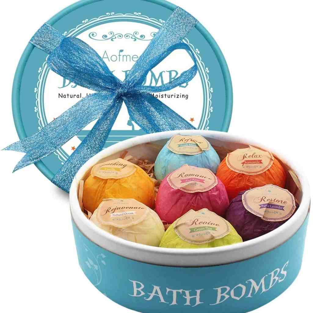 Colorful bath bomb gift set in a decorative blue box with a ribbon, featuring six scented bombs for various relaxation purposes.
