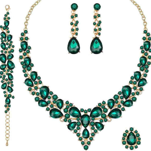 Elegant emerald green crystal jewelry set including a necklace, matching bracelet, drop earrings, and a gold-accented ring.