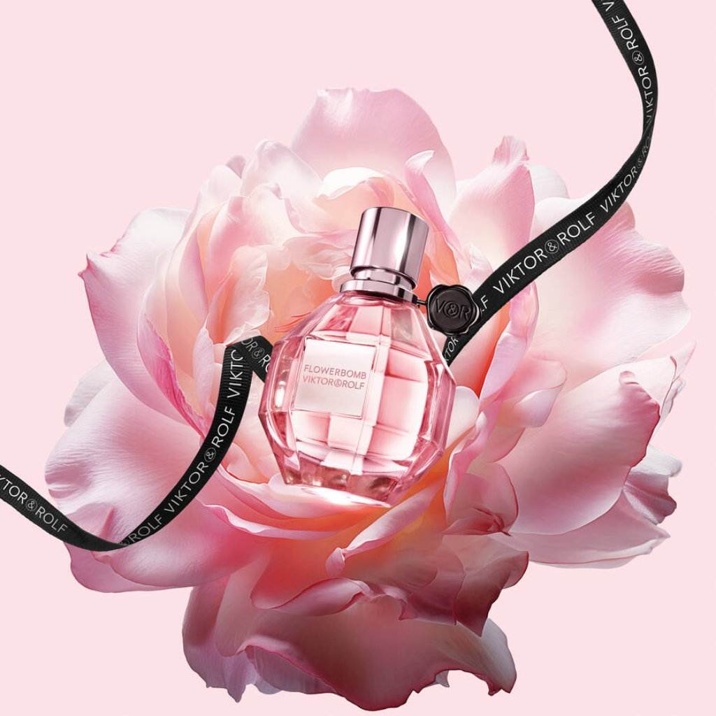 Flowerbomb by Viktor & Rolf: a pink, diamond-shaped bottle adorned with soft pink petals and a branded ribbon, classy and elegant.