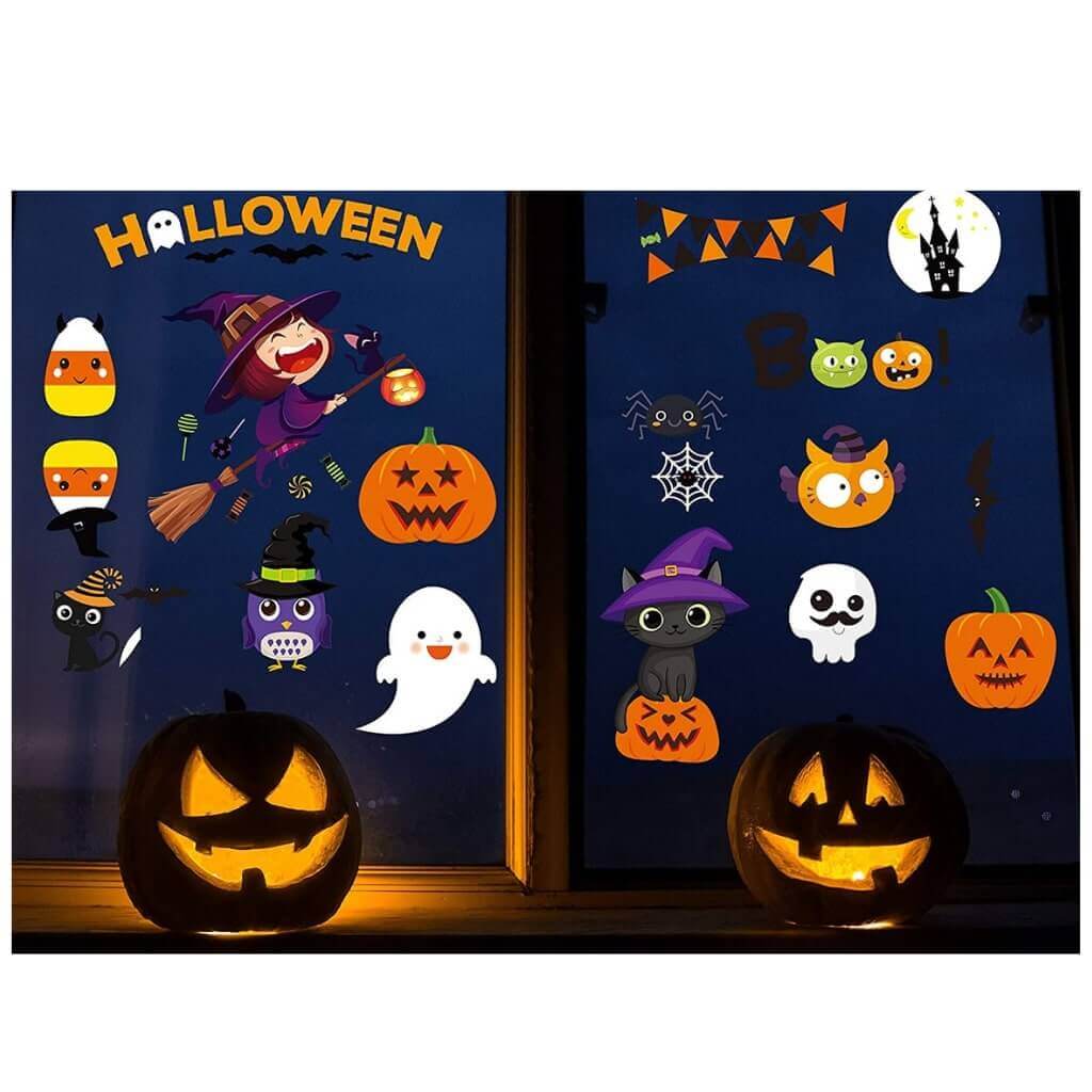 Colorful Halloween window clings with pumpkins, ghosts, witches, and black cats, lit by two jack-o'-lanterns for a festive look.