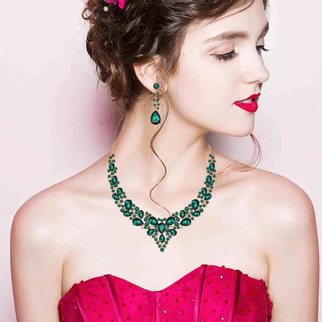 Model adorned in an elegant green gemstone necklace and matching drop earrings, paired beautifully with a vibrant pink dress.