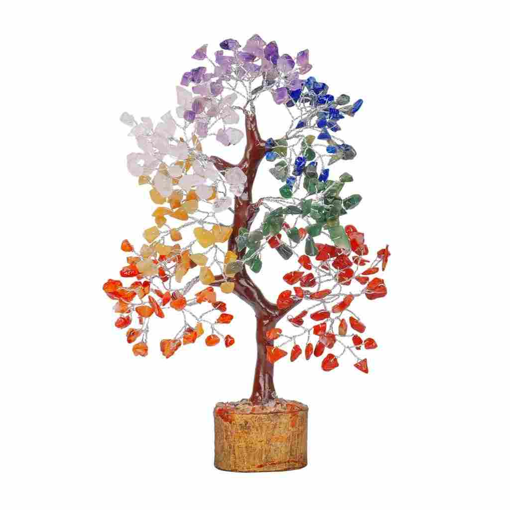 A decorative gemstone tree with multicolored crystal leaves representing the chakras, placed on a wooden base.