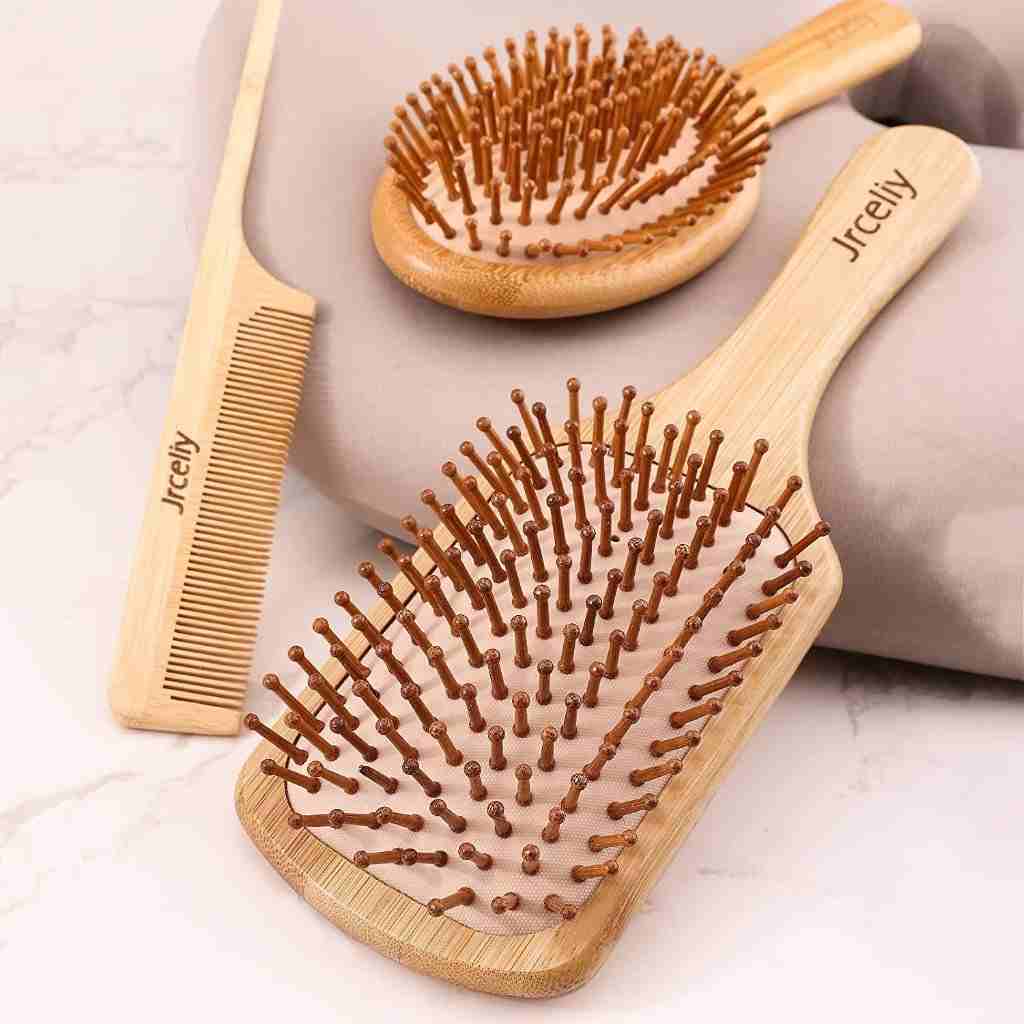 Wooden hairbrush and comb set with flexible bristles displayed on a soft surface, showing natural and eco-friendly design.