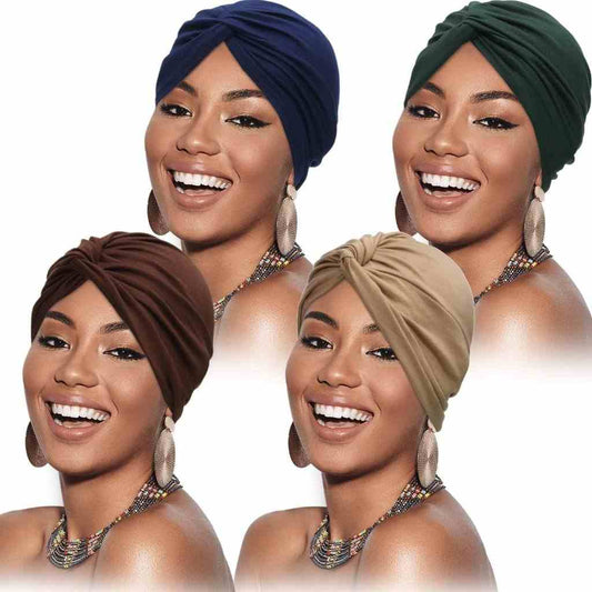 A diverse group of women wearing four different colored turbans: navy blue, dark green, brown, and beige.