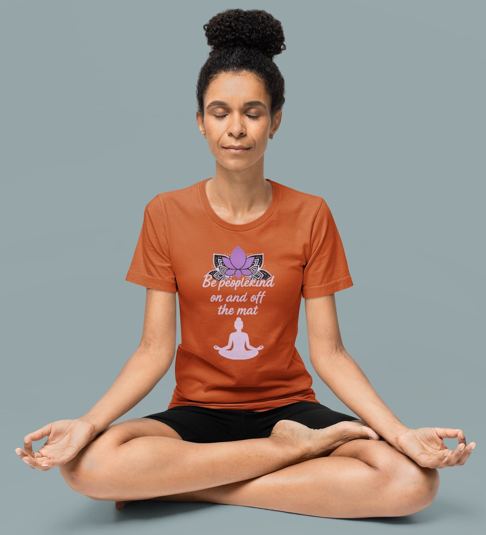 Woman in autumn Be Peoplekind yoga shirt meditating cross-legged, promoting mindfulness and inner peace through calm apparel.