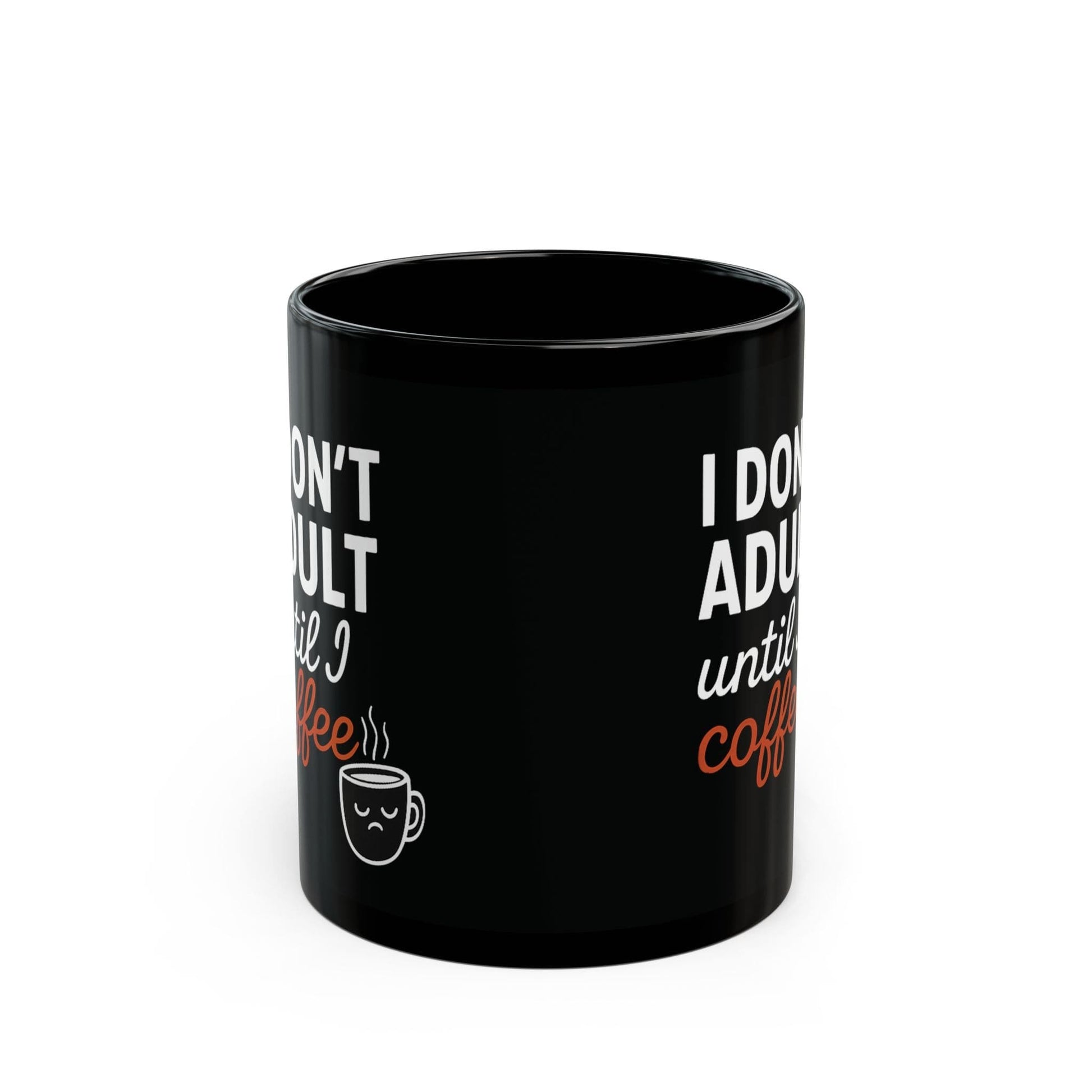 Black ceramic coffee mug with “I don’t adult until I coffee” quote printed on both sides, front view with sleepy face icon.