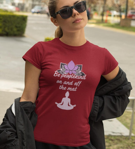 Woman wearing cardinal Bella Canvas 3001 yoga shirt with "Be peoplekind" quote, standing outdoors in sunglasses.