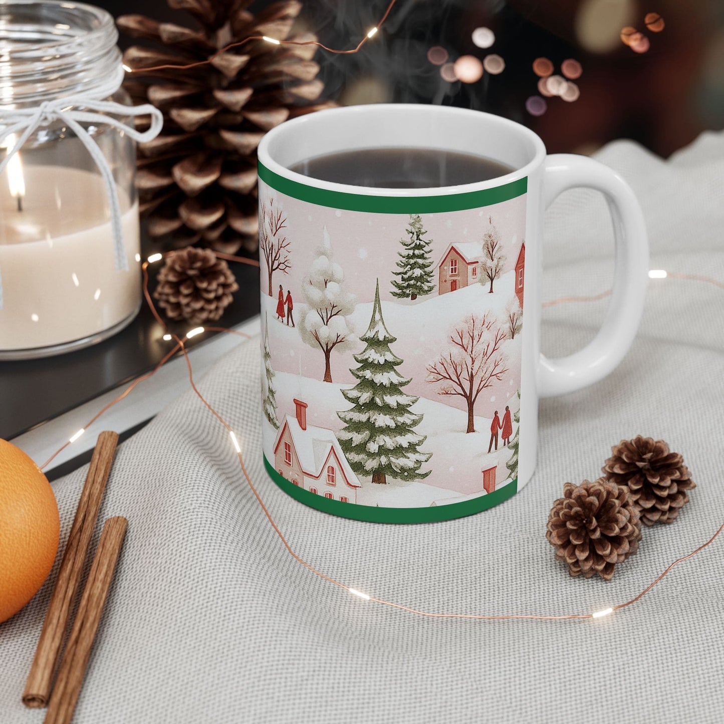 Christmas mug with winter village design on festive table with pinecones, cinnamon, candle, and holiday lights.