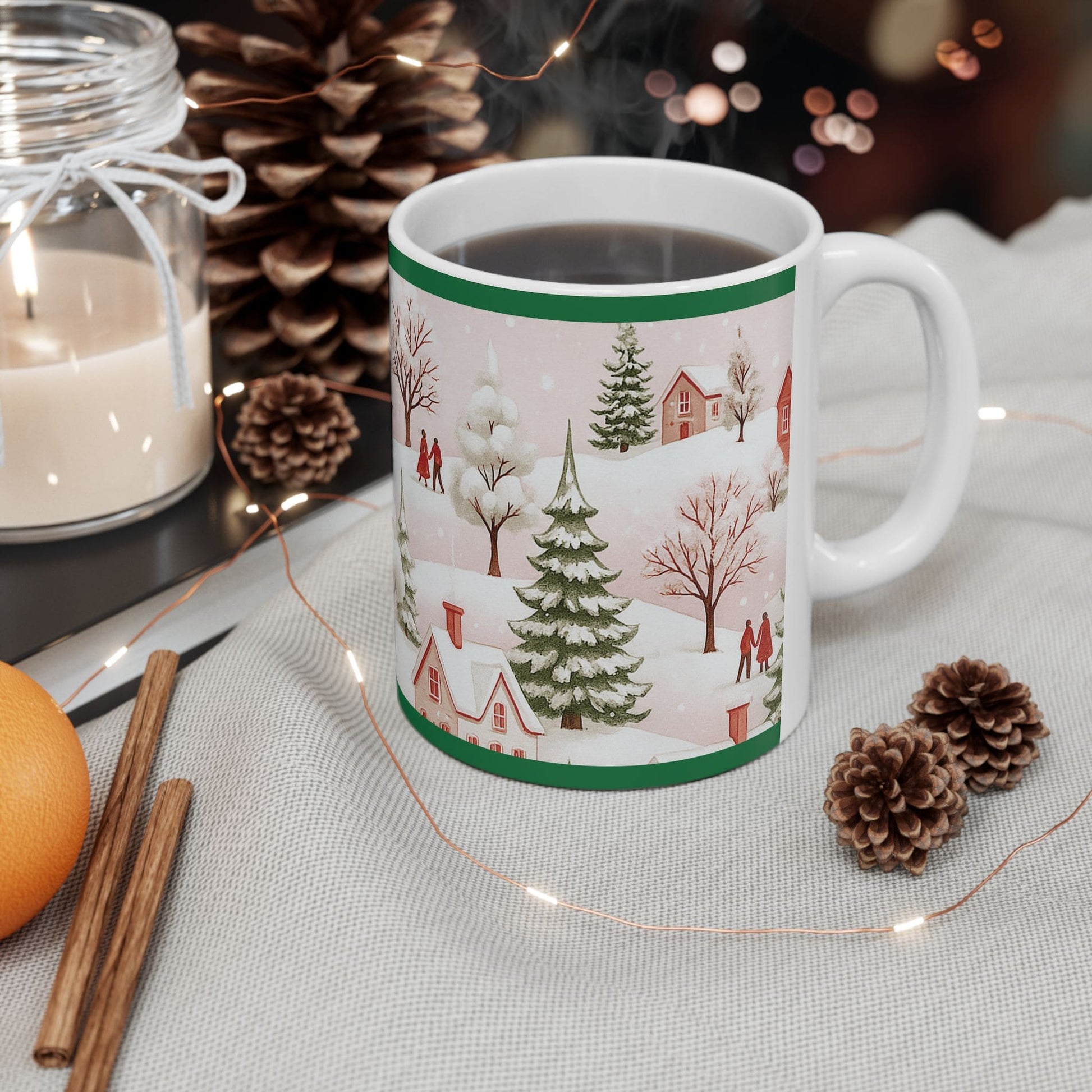 Christmas mug with winter village design on festive table with pinecones, cinnamon, candle, and holiday lights.