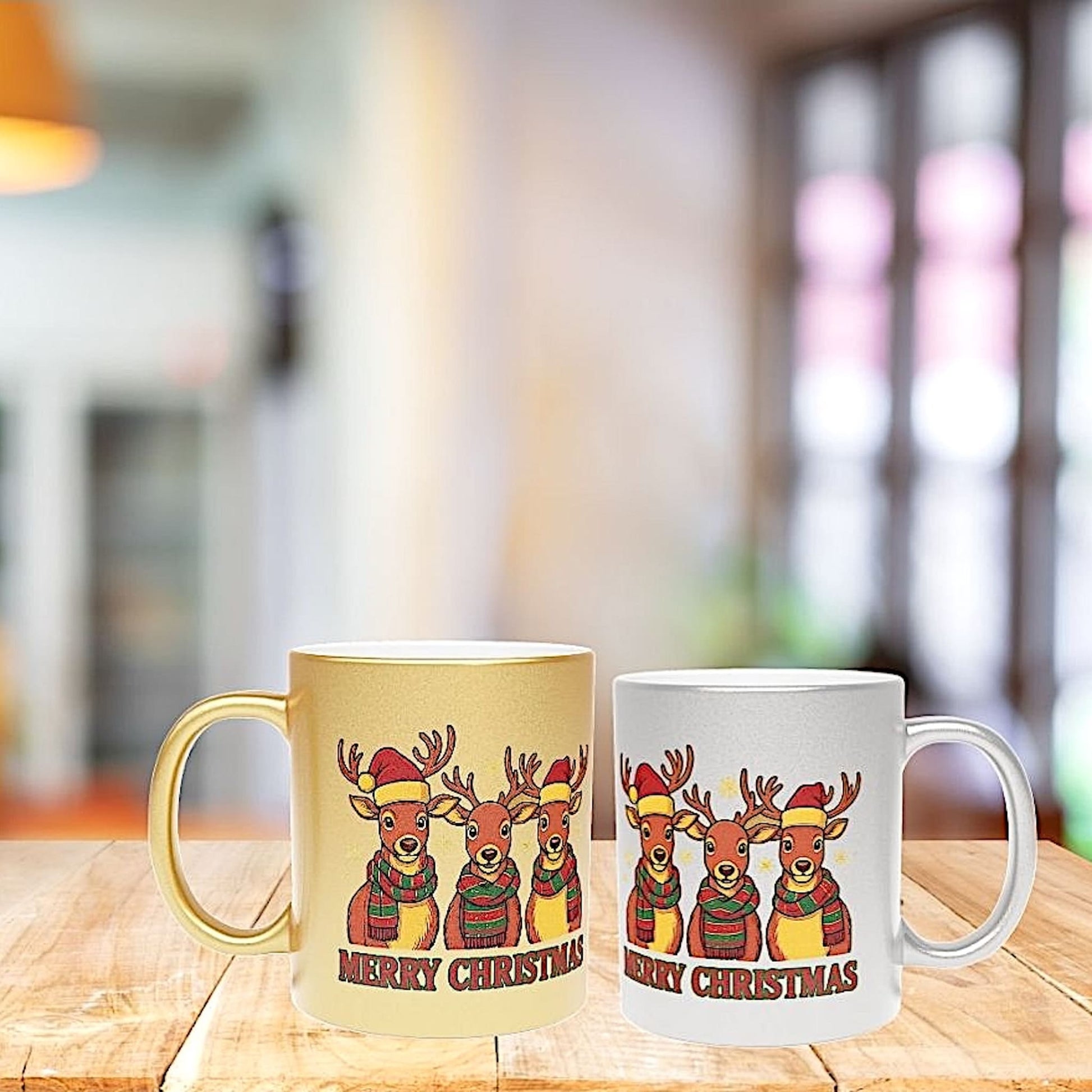 Side-by-side gold and silver metallic mugs with festive reindeer design and Merry Christmas text, displayed on a wooden table with warm blurred background.
