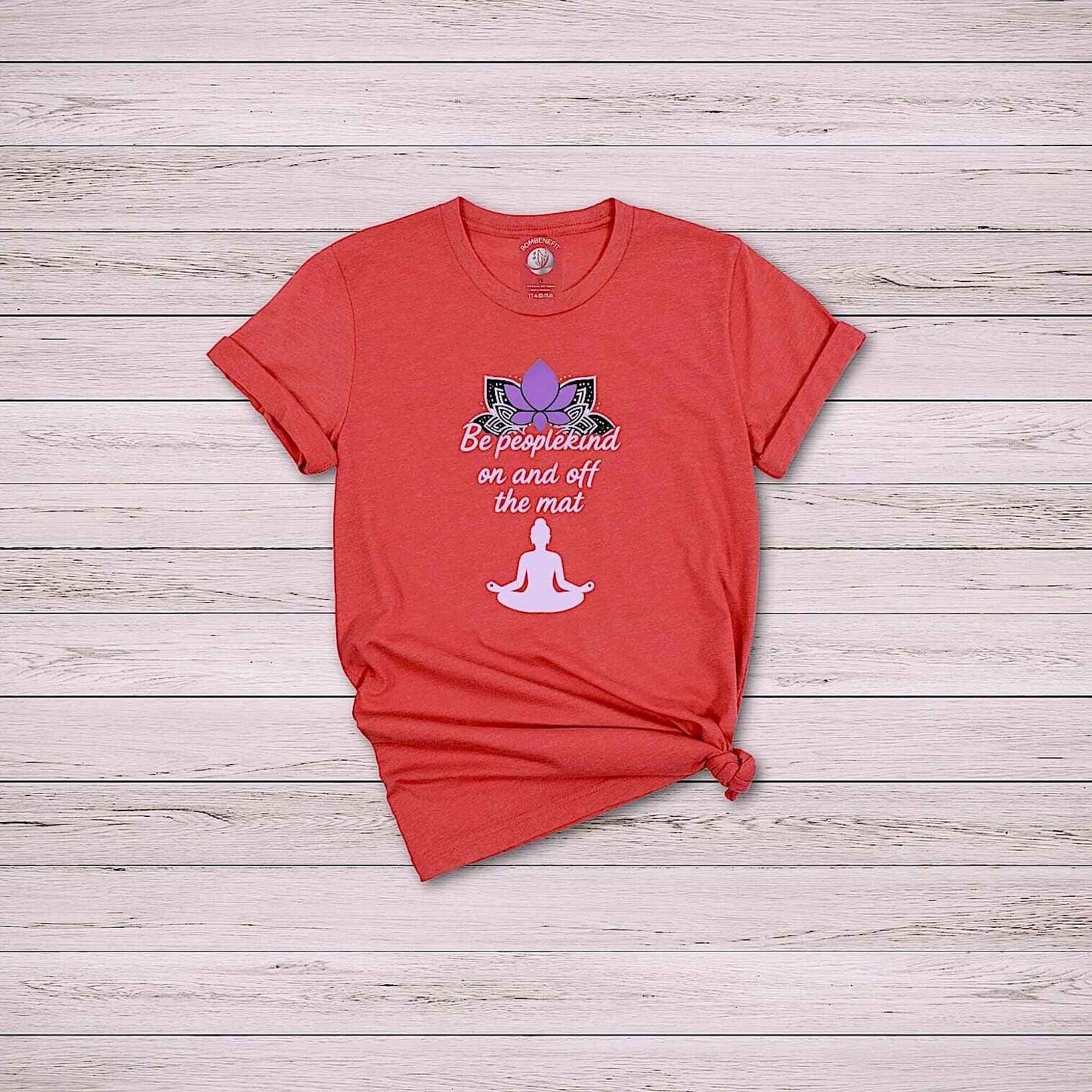 Flat lay of Heather Red Bella Canvas 3001 t-shirt with yoga quote “Be peoplekind” and lotus design on wooden background