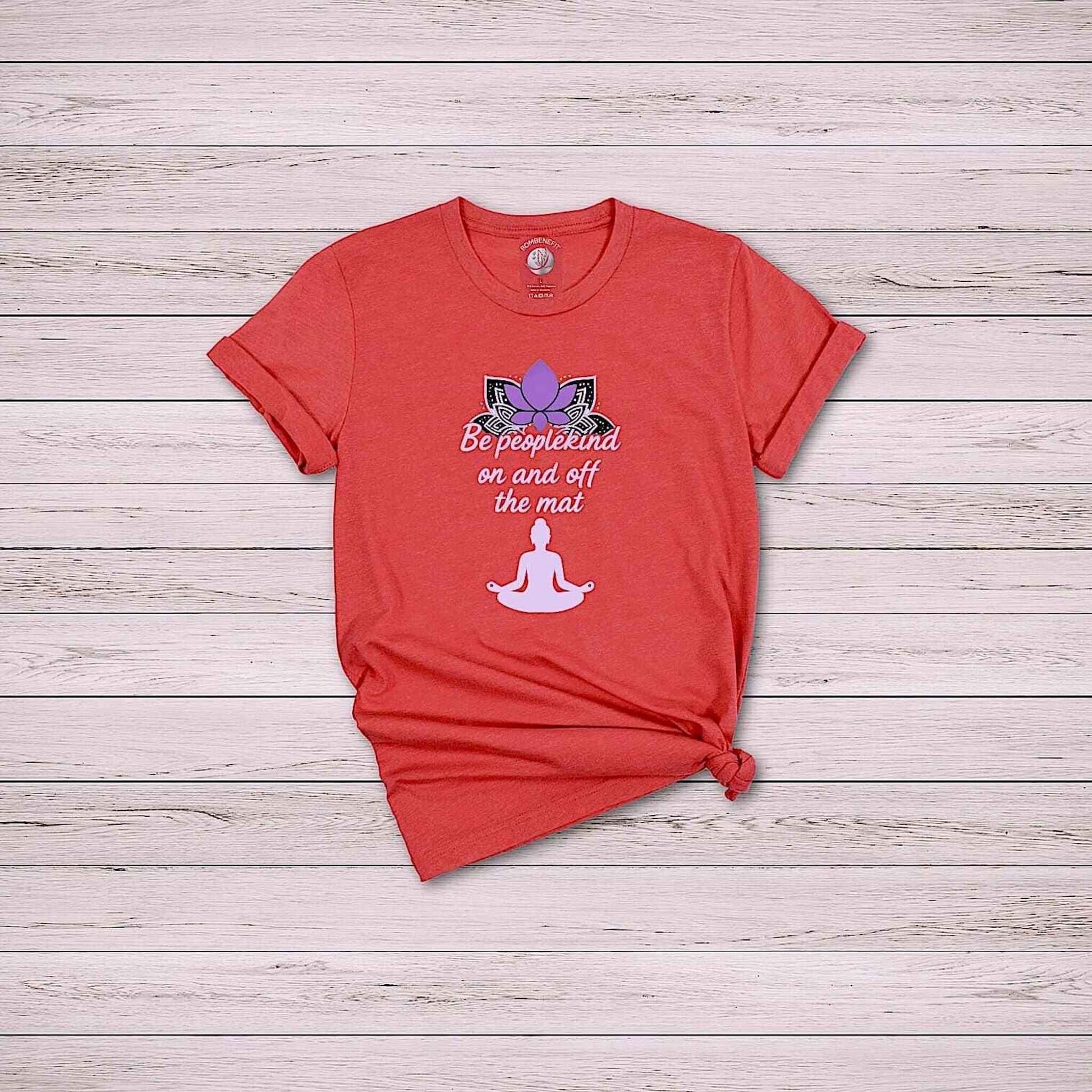 Flat lay of Heather Red Bella Canvas 3001 t-shirt with yoga quote “Be peoplekind” and lotus design on wooden background