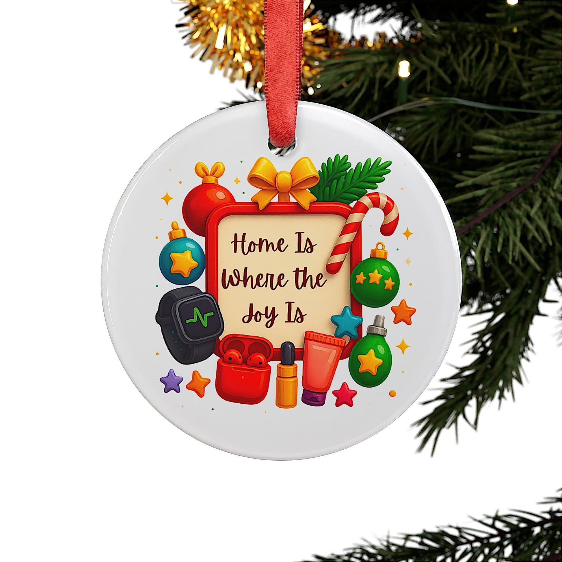 Christmas ornament with the phrase “Home Is Where the Joy Is” hanging from a pine tree branch, surrounded by festive decorations.