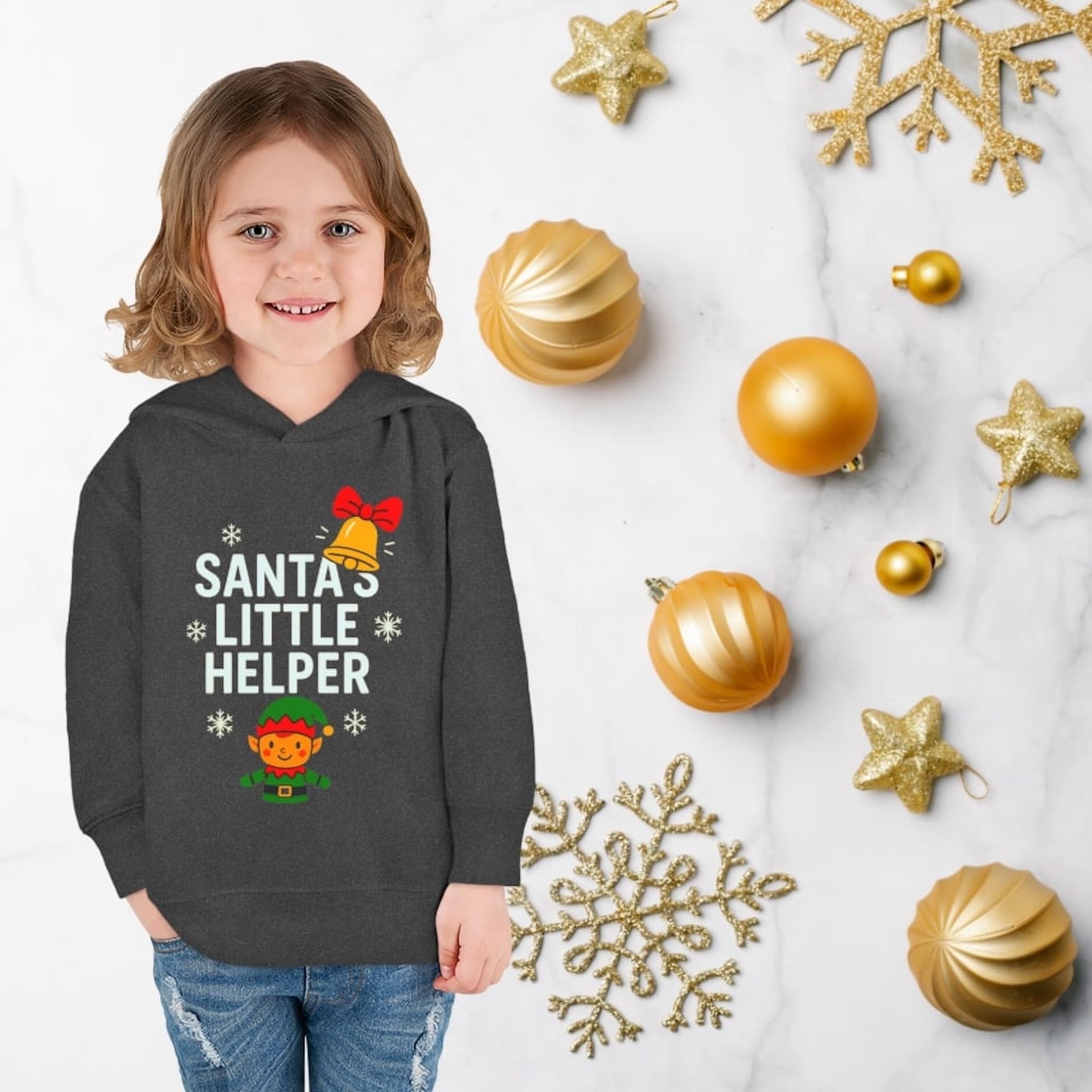 Child wearing vintage smoke hoodie with Santa’s Little Helper design, featuring elf, bell, and snowflakes, cute Christmas outfit.
