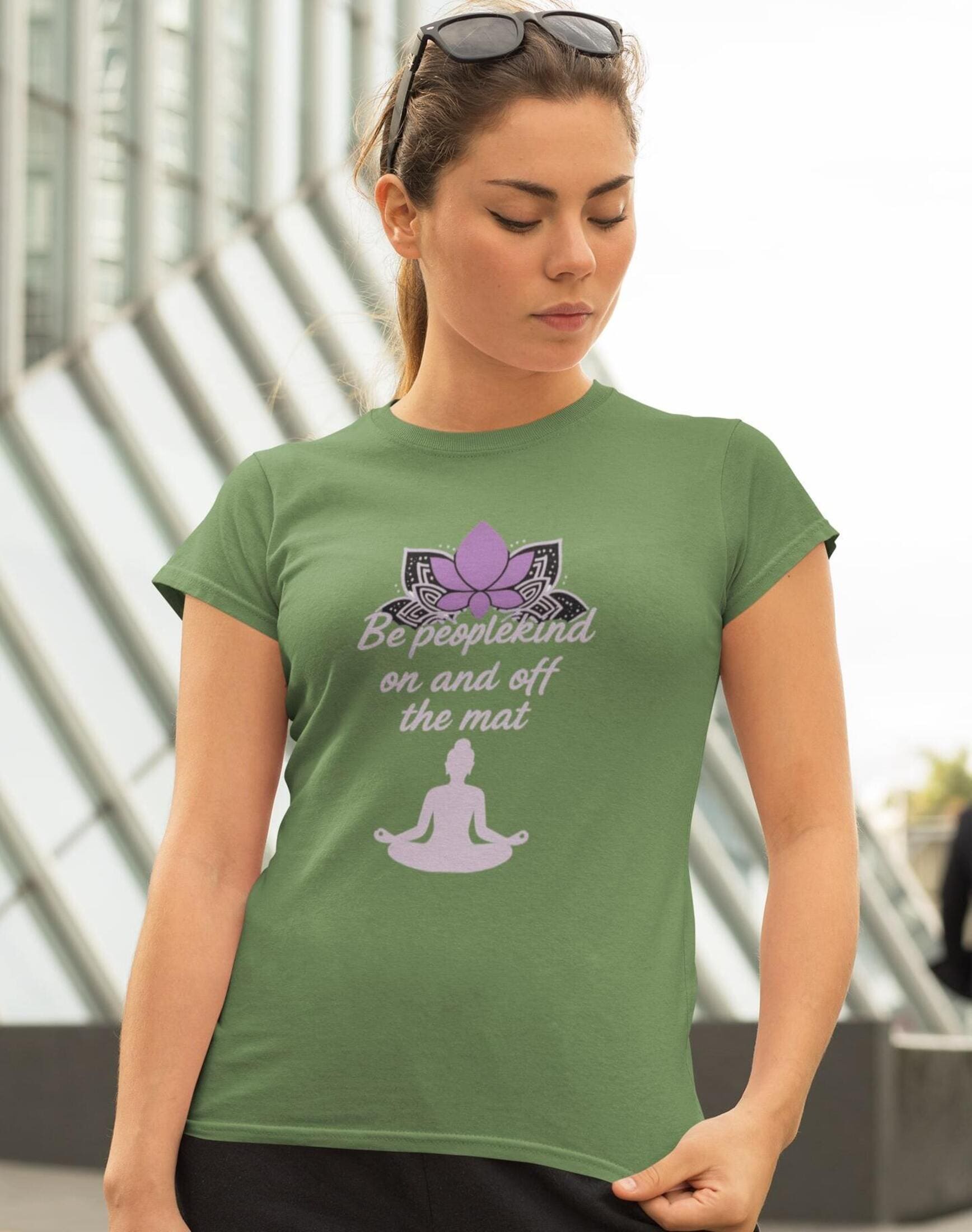 Leaf green Bella Canvas 3001 yoga t-shirt with purple lotus and Be peoplekind on and off the mat quote, worn by woman outdoors