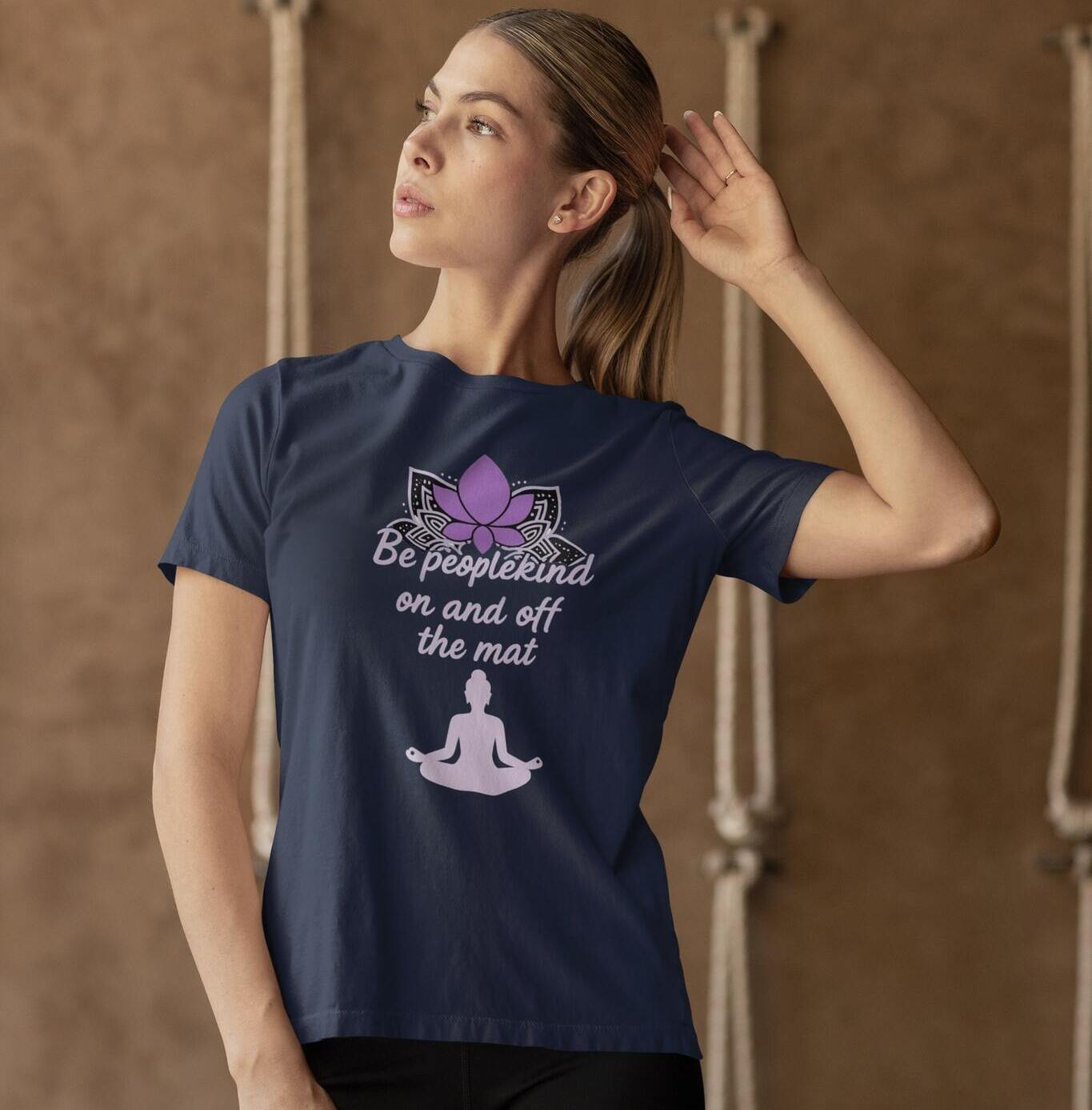 Navy blue yoga t-shirt with 'Be peoplekind on and off the mat' phrase and lotus mandala design, worn by a woman
